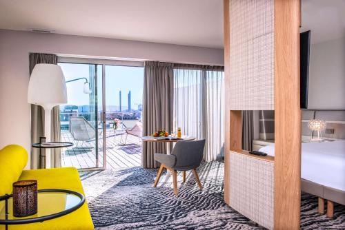 um quarto de hotel com uma cama king-size e uma varanda em Radisson Blu Hotel Bordeaux em Bordeaux