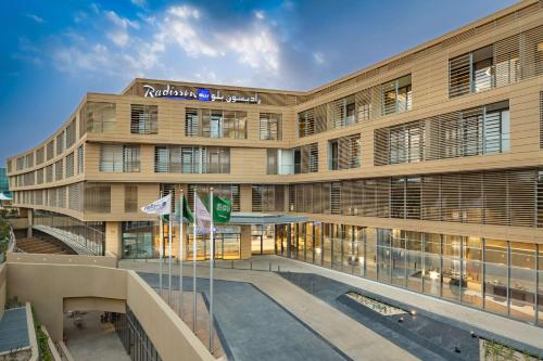 a large building with flags in front of it at Radisson Blu Hotel & Residence, Riyadh Diplomatic Quarter in Riyadh