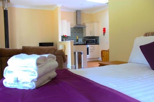 a bedroom with a bed with a hand on it at Auchendennan Farm Self Catering Cottages in Balloch
