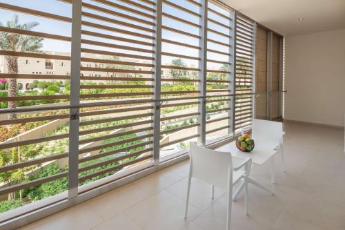 a dining room with a large window with blinds at Radisson Blu Hotel & Residence, Riyadh Diplomatic Quarter in Riyadh