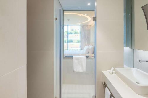 a bathroom with a shower and a sink and a mirror at Radisson Blu Hotel & Residence, Riyadh Diplomatic Quarter in Riyadh