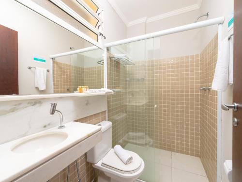 a bathroom with a toilet and a sink and a shower at Hotel Costa Norte Massaguaçu in Caraguatatuba