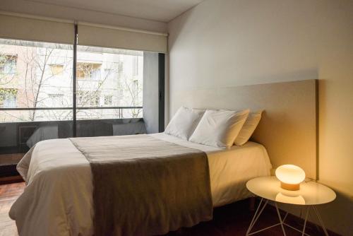Un dormitorio con una cama grande y una ventana en Departamentos Lugar en Córdoba
