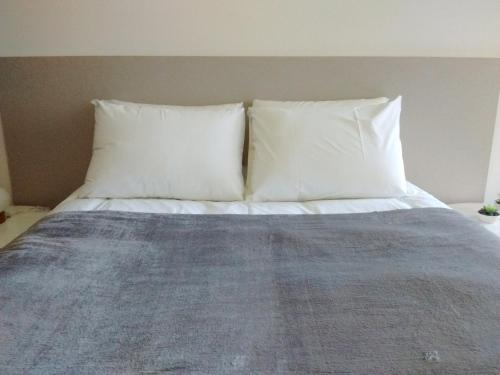 a bed with two pillows on top of it at Departamentos Lugar in Cordoba
