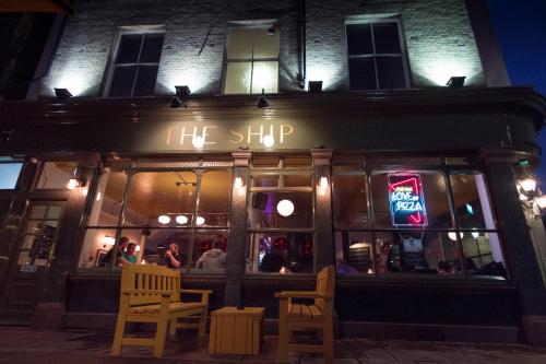 a restaurant with a sign that reads the shop at night at The Ship Rooms in London
