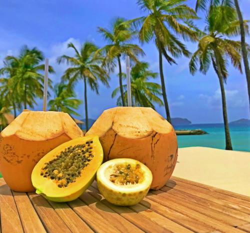two halves of melons sitting on a table near the ocean at The Liming Bequia in Friendship
