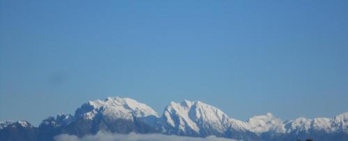 a view of a mountain range with clouds in the foreground at Agriturismo La Casa Nei Boschi in Colderù