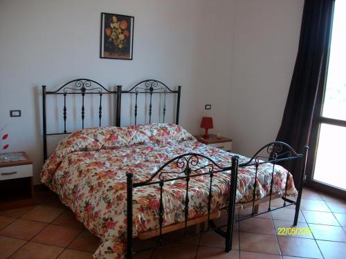 a bedroom with a bed with a floral comforter at COUNTRY HOUSE SUL BUSSENTO in Torre Orsaia