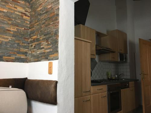 a kitchen with wooden cabinets and a brick wall at Haus Eder Steiner in Saalbach Hinterglemm