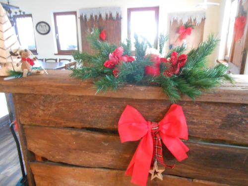 a wooden counter with christmas wreaths and a red bow at Agriturismo La Casa Nei Boschi in Colderù