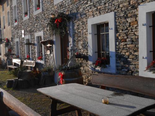 a picnic table in front of a building with flowers at Agriturismo La Casa Nei Boschi in Colderù
