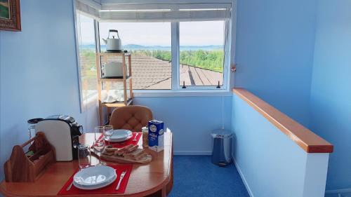 Panoramic View Apartment Without a Kitchen في روتوروا: غرفة صغيرة مع طاولة ونافذة