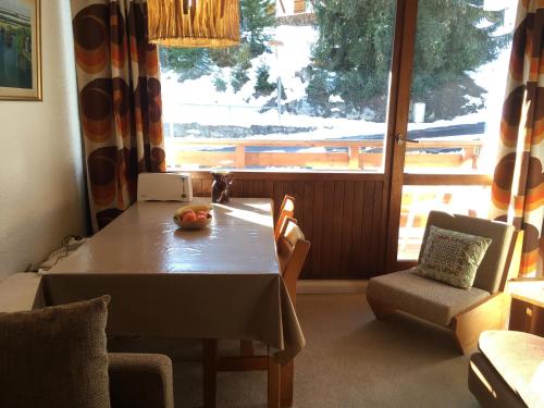 a dining room with a table and a large window at Le Solaret in Courchevel
