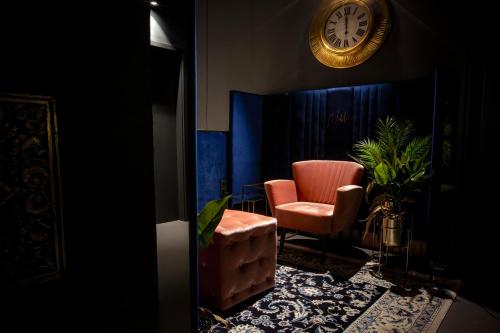 a room with a chair and a clock on the wall at Noble Boutique Hotel - Adults Only in Budapest
