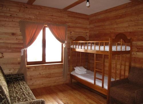 a bedroom with two bunk beds in a log cabin at Полонянка in Bukovinka