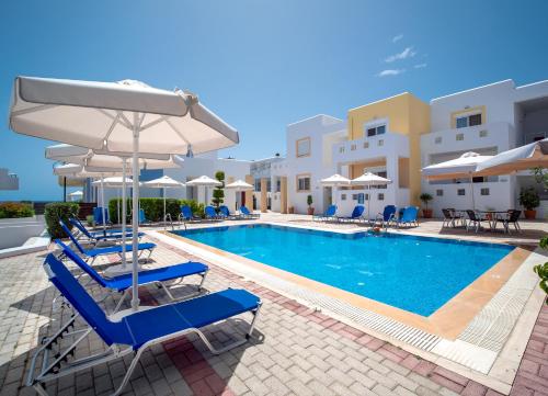 una piscina con sedie e ombrelloni in un resort di Gennadi Gardens Apartments & Villas a Gennadi