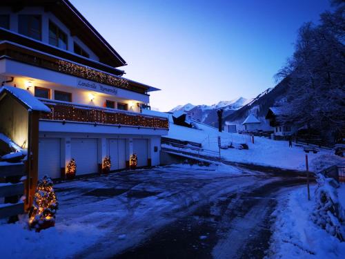 a building with christmas lights in the snow at Landvilla Romantika in Lermoos