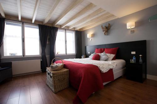 een slaapkamer met een groot bed met rode kussens bij The Abiente Rooms in Brugge