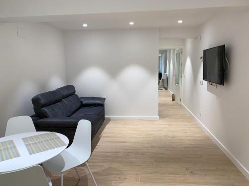 a living room with a black couch and a table at ALDAMAR parking incluido in Getaria
