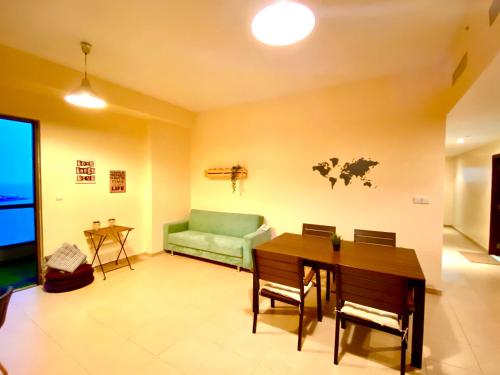 a living room with a green couch and a table at Bombay Backpackers DXB in Dubai