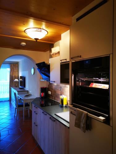 a kitchen with a stove top oven next to a table at Landvilla Romantika in Lermoos