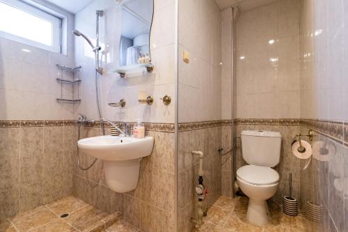 een badkamer met een toilet, een wastafel en een douche bij BGApartments - Chataldzha in Varna