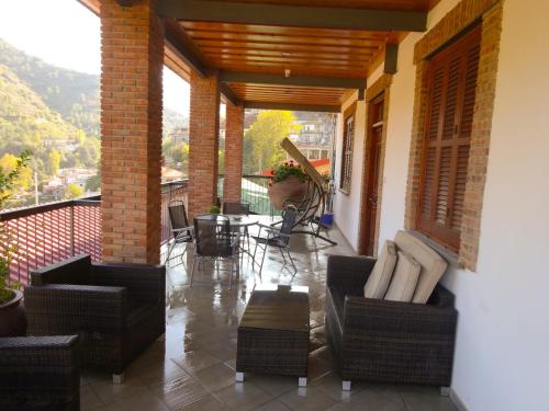 a porch with chairs and a table on a balcony at Archontiko I Misirlou in Kalopanayiotis