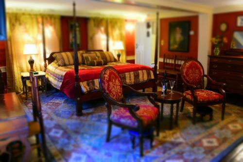a bedroom with a bed and two chairs and a table at Daniels House Inn in Salem