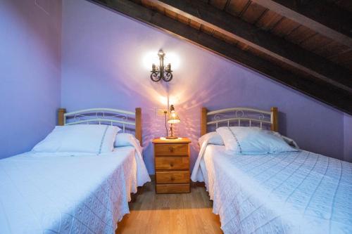 PorrúaにあるEl Llagu Villa Megustaruralの紫の壁のベッドルーム1室(ベッド2台付)