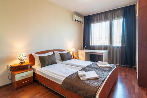 een slaapkamer met een bed met twee handdoeken erop bij BGApartments - Chataldzha in Varna