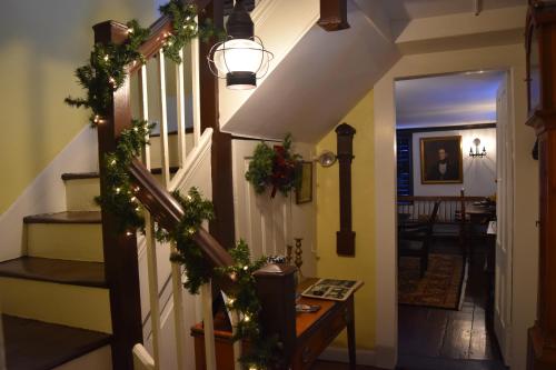 a hallway with a staircase with christmas garland at Daniels House Inn in Salem
