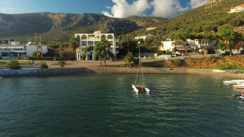 a sailboat floating in the water in a city at Antikyra Beach Hotel in Antikyra