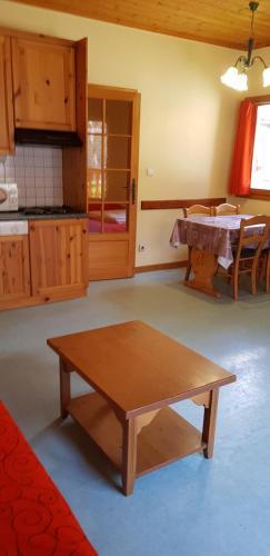 a living room with a wooden table and a kitchen at Alpes Roc in Pralognan-la-Vanoise