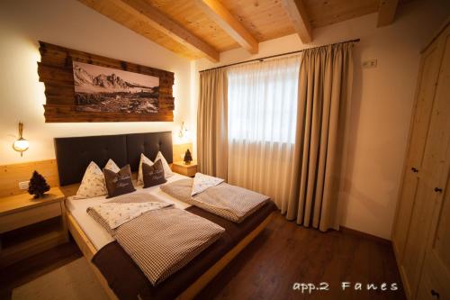 une chambre avec un lit dans une pièce avec une fenêtre dans l'établissement Alp Residence Pelegrin, à San Vigilio Di Marebbe