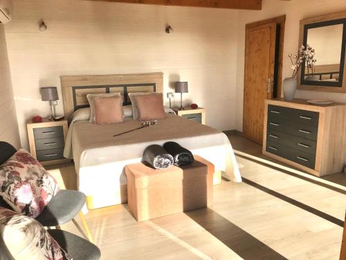 a bedroom with a large bed and a chair at Finca La Paz in San Miguel de Abona