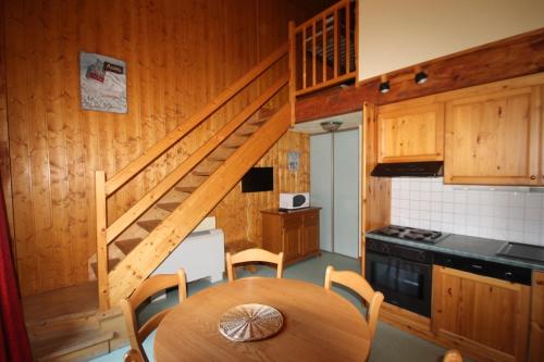 a kitchen with a wooden staircase and a wooden table at Alpes Roc in Pralognan-la-Vanoise