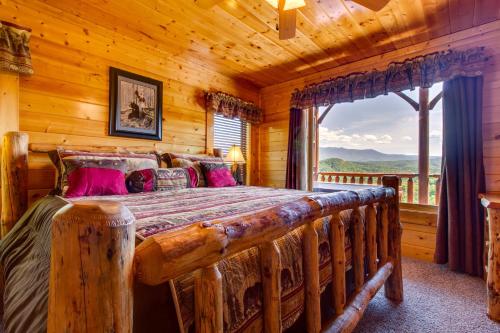 a log cabin bedroom with a bed and a large window at Cub Castle in Pigeon Forge