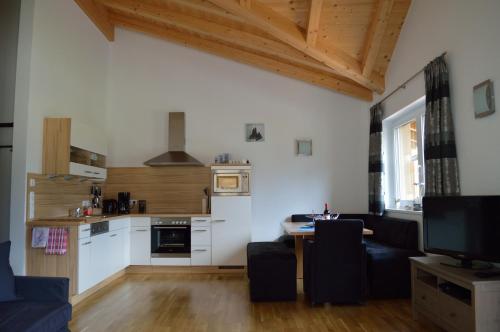ein Wohnzimmer mit einem Tisch und einer Küche in der Unterkunft Haus Klein Rosental in Neukirchen am Großvenediger