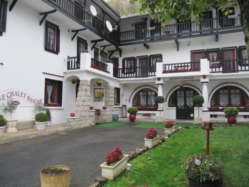 a large white building with windows and a courtyard at Le Chalet Basque in Capvern