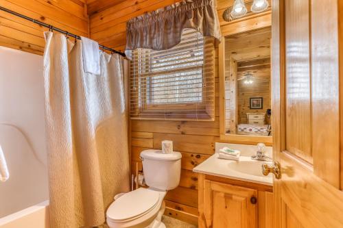 a bathroom with a toilet and a sink and a tub at Heavens Scent in Pigeon Forge