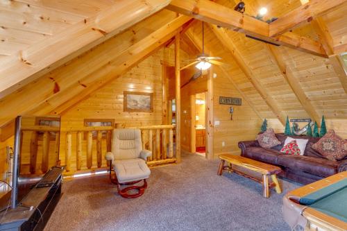 a living room with a couch and a chair in a cabin at Tennessee Treasure in Pigeon Forge