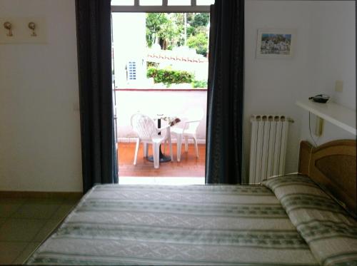 a bedroom with a bed and a view of a patio at Hotel Castiglione in Ischia