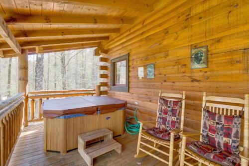 a log cabin with a stove and chairs on a deck at Tennessee Treasure in Pigeon Forge