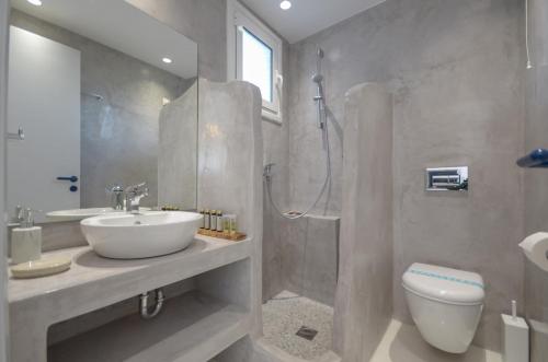 a bathroom with a sink and a shower and a toilet at Nostos Studios at Saint George beach Agios Georgios Chora Naxos town in Naxos Chora