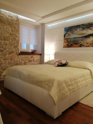a bedroom with a bed and a stone wall at V&M Luxury Studio in Pag