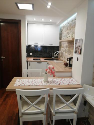a kitchen with a table and two chairs and a kitchen with white cabinets at V&M Luxury Studio in Pag