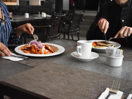 a group of people sitting at a table with plates of food at Sunio City in Tijuana