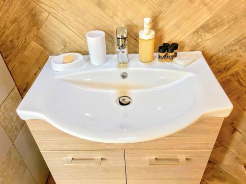 a bathroom sink with soap and cosmetics on it at SEMIRAMIS SUITES with pool in Kalamata