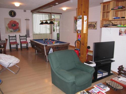 a living room with a pool table and a chair at Le Chalet Basque in Capvern