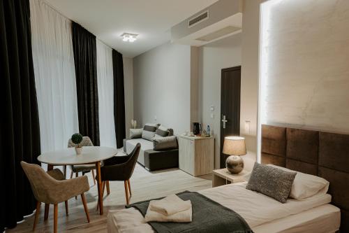 a room with a bed and a table and a couch at Apartamenty i Pokoje InforesPark in Przemyśl